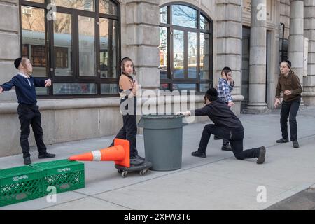 Yeshiva-Schüler und -Mitschüler spielen ein mysteriöses Spiel von Lauf und Tag. Auf den Straßen von Brooklyn an einem warmen Wintertag im Jahr 2024. Stockfoto