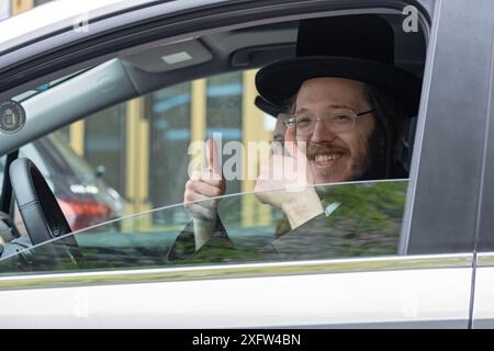 Ein lächelnder chassidischer jüdischer Mann gibt diesem Foto einen Daumen hoch und ein großes Lächeln. In Williamsburg, Brooklyn, New York. Stockfoto