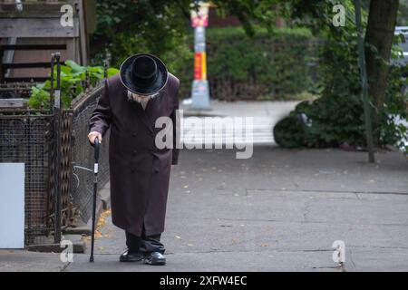 Ein älterer, nicht identifizierbarer chassidischer jüdischer Mann geht langsam zur Synagoge in Brooklyn, New York. Stockfoto