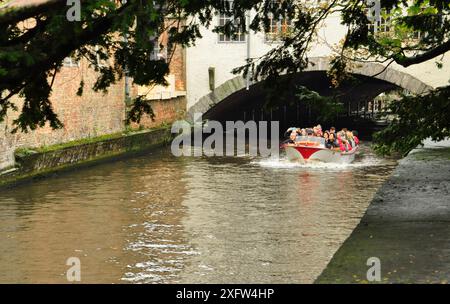 30-10-2014 Brügge, Belgien - aus einem Tunnel auf Brügge-Kanälen steigt Ein Boot voller Touristen hervor Stockfoto