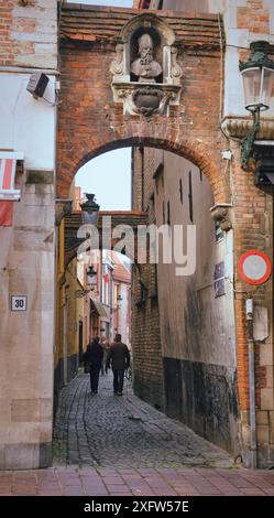 30-10-2014 Brüssel, Belgien - die malerische Gasse von Brügge mit markanten Ziegelbögen und einer bemerkenswerten Skulptur ist ein gemütliches Erlebnis Stockfoto