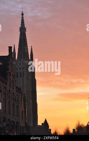 30-10-2014 Brüssel, Belgien - die Kirche unserer Lieben Frau in Brügge leuchtet vor einer atemberaubenden orangen Kulisse bei Sonnenuntergang Stockfoto