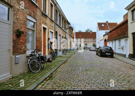 30-10-2014 Brügge, Belgien - Eine malerische Kopfsteinpflasterstraße in Brügge mit typischen Häusern und Fahrrädern an den Eingängen Stockfoto