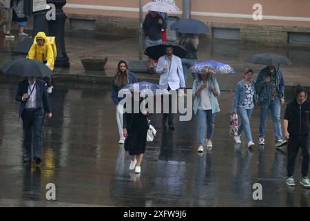 Sankt Petersburg, Russland. Juli 2024. Die Leute unterbringen sich unter Sonnenschirmen, während sie bei starkem Regen auf der Straße im Zentrum von St. Petersburg spazieren. (Foto: Maksim Konstantinov/SOPA Images/SIPA USA) Credit: SIPA USA/Alamy Live News Stockfoto