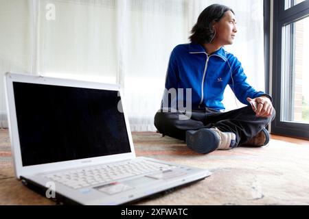 Japanische junge Mann mit Laptop-Computer im Zimmer Stockfoto