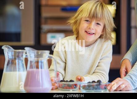 Familie in der Küche. Kind. Gesunde Ernährung. Gesundes Wachstum. Milchshakes mit Beeren zu machen. Stockfoto