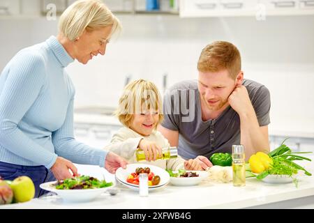 Familie in der Küche. Drei Generationen. Gesunde Ernährung. Gesundes Wachstum. Gemüsesalat machen. Stockfoto