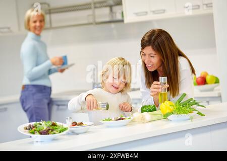 Familie in der Küche. Drei Generationen. Gesunde Ernährung. Gesundes Wachstum. Gemüsesalat machen. Stockfoto