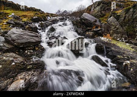 Idwal Falls auf dem Weg von Idwal Cottage, Llyn Ogwen zum Llyn Idwall, dem Gipfel von Y Garn im Hintergrund. Snowdonia-Nationalpark, Nordwales, Großbritannien. Februar 2017. Stockfoto