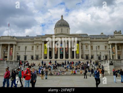 Die National Portrait Gallery am Trafalgar Square mit einer Reihe von Besuchern, die auf den Stufen sitzen und herumlaufen Stockfoto