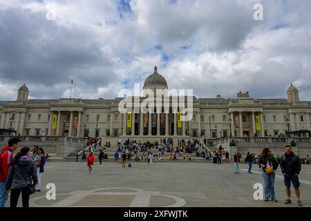 Die National Portrait Gallery am Trafalgar Square mit einer Reihe von Besuchern, die auf den Stufen sitzen und herumlaufen Stockfoto