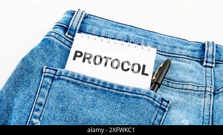 Geschäftskonzept. Text PROTOCOL ist auf einem Notizbuch auf Jeans auf weißem Hintergrund geschrieben Stockfoto