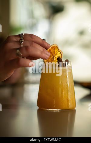Der Barkeeper dekorierte einen Cocktail mit einer Orangenscheibe. Sommergetränk. Stockfoto