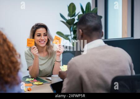 Fröhliche Geschäftsfrau motiviert Kollegen während der Arbeit im Büro Stockfoto