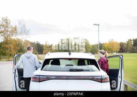 Mann und Frau, die auf dem Parkplatz stehen Stockfoto