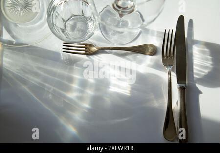 Direkt über dem Schuss der Gabeln und Tischmesser mit Brille auf dem Tisch Stockfoto