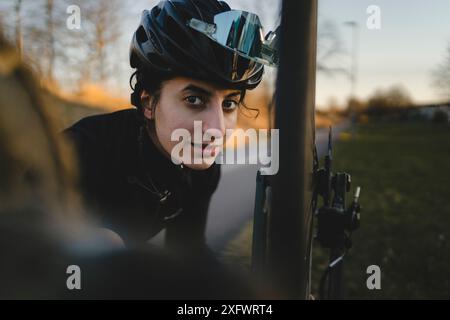 Porträt einer mittelerwachsenen Frau, die Fahrrad im Hinterhof repariert Stockfoto