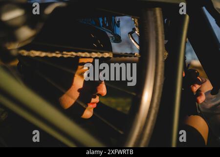 Nahaufnahme einer mittelerwachsenen Frau, die Fahrrad im Hinterhof repariert Stockfoto