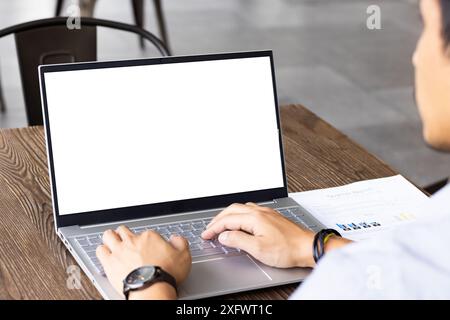 Auf dem Laptop tippen, Mann, der am Geschäftsbericht arbeitet, am Holztisch, Kopierraum Stockfoto