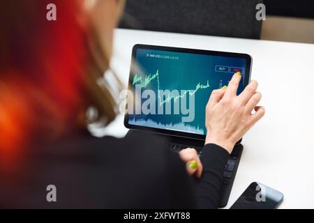 Geschäftsfrau, die im Büro über einen Tablet-PC handelt Stockfoto
