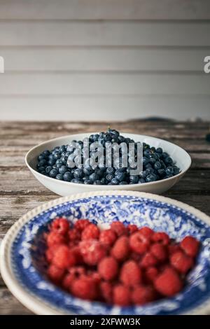 Nahaufnahme von Beeren in Schüsseln auf Holztisch Stockfoto