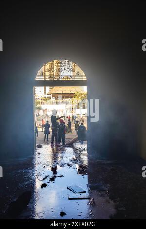 Nairobi, Kenia - 25. Juni 2024. Demonstranten stehen vor dem verbrannten Eingang zum Rathaus von Nairobi, dem Sitz des Gouverneurs der Grafschaft Nairobi. Stockfoto