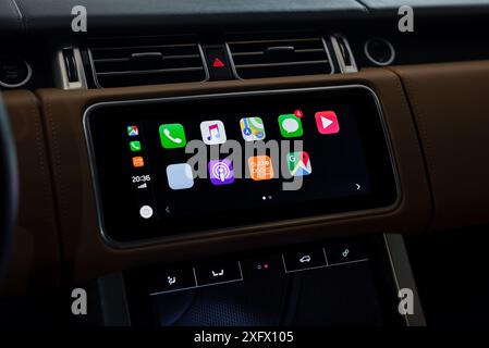 Apple CarPlay Hauptmenü im Executive Car. Innenraum mit Lederbesatz bei Nacht, Nahaufnahme des Infotainment-Systems. Stockfoto