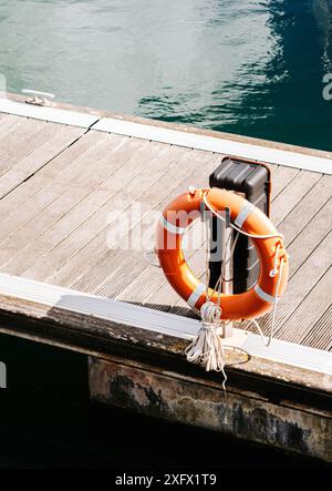 Rettungsschwimmer im Yachthafen. Rettungsring einer roten Boje an einem Pfosten am Flussufer Stockfoto