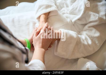 Frau mit grünem Armband Konsolen weibliche Patientin im Krankenhauszimmer Stockfoto