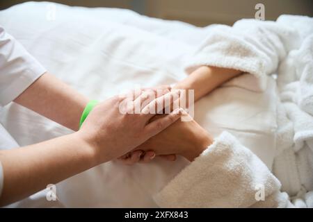 Arzt konsolert weibliche Patientin im Krankenhauszimmer Stockfoto