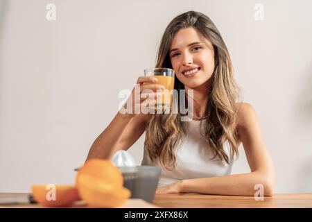 Frau trinkt Orangensaft - gesunder Lebensstil - frisches Getränk, lächelnde Frau - Ernährung und Wellness, Vitamin C - erfrischendes Getränk. Stockfoto