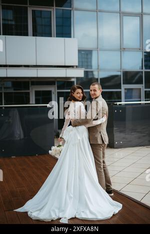 Braut und Bräutigam treffen sich auf dem Dach eines Wolkenkratzers Stockfoto