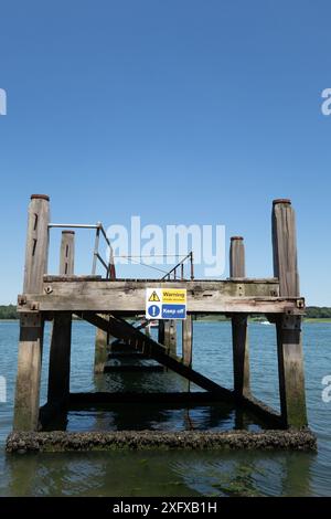 Warnschild für eine unsichere Baustelle an einem alten Steg in Woolverstone am Orwell River Suffolk England. Stockfoto