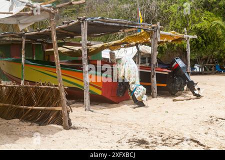 Detailansicht der farbenfrohen Boote, die den Strand unter rustikalen Unterkünften in Salt Whistle Bay, Mayreau, Saint Vincent und den Grenadinen hinaufzogen. Stockfoto