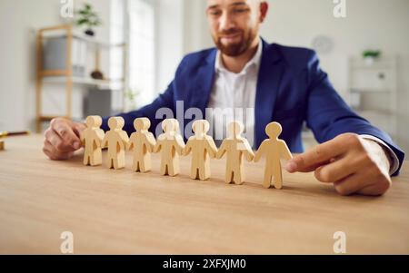 HR-Manager, der eine Reihe menschlicher Zahlen anführt, die das Konzept des Personalmanagements zeigen Stockfoto