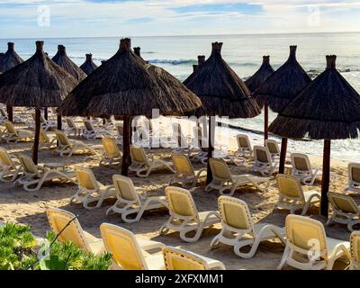 Strohschirme und Sonnenliegen an einem weißen und goldenen Sandstrand in der Karibik, ein idealer Ort, um Sommerurlaub zu genießen und sich von den Blicken zu erholen Stockfoto