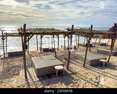 Balinesische Betten an einem Strand mit feinem goldenem Sand unter der glitzernden karibischen Sonne und dem Meer im Hintergrund, eine ideale Umgebung für einen Sommerurlaub Stockfoto