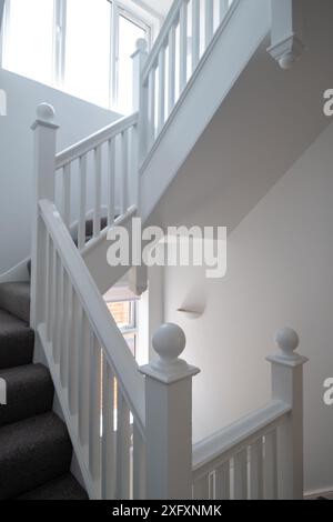 Renovierte, weiß lackierte Holztreppe mit einfachen vertikalen Leisten, in einem edwardianischen Haus im Nordwesten Londons, Großbritannien. Stockfoto