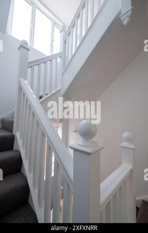 Renovierte, weiß lackierte Holztreppe mit einfachen vertikalen Leisten, in einem edwardianischen Haus im Nordwesten Londons, Großbritannien. Stockfoto