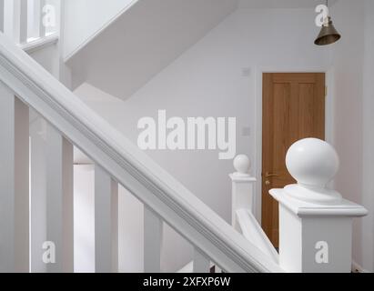 Renovierte, weiß lackierte Holztreppe mit einfachen vertikalen Leisten, in einem edwardianischen Haus im Nordwesten Londons, Großbritannien. Stockfoto
