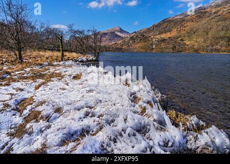 Eisformationen am Ufer von Llyn Gwynant, Blick nach Westen bis Yr Aran. Snowdonia-Nationalpark, Gwynedd, Wales, Großbritannien. März 2018. Stockfoto