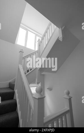 Renovierte, weiß lackierte Holztreppe mit einfachen vertikalen Leisten, in einem edwardianischen Haus im Nordwesten Londons, Großbritannien. Stockfoto