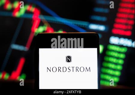 In dieser Fotoabbildung wird das Logo der amerikanischen Kette von Luxusschmuck-Kaufhäusern Nordstrom (NYSE: JWN) auf einem Smartphone mit einem wirtschaftlichen Börsenindex im Hintergrund angezeigt. Stockfoto