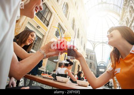 Freunde cheers mit Getränken in der Galerie Umberto Primo in Neapel. Stockfoto