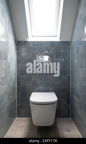 Kleine Toilette in Loft-Umbau mit cleverem Gebrauch der Traufe auf dem Dachboden. Architekt entworfen mit blauen Porzellan zellige Fliesen, weiße Wand hängende Toilette. Stockfoto