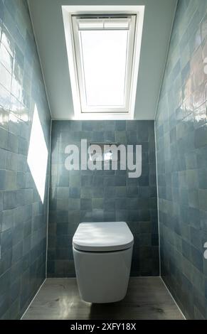 Kleine Toilette in Loft-Umbau mit cleverem Gebrauch der Traufe auf dem Dachboden. Architekt entworfen mit blauen Porzellan zellige Fliesen, weiße Wand hängende Toilette. Stockfoto