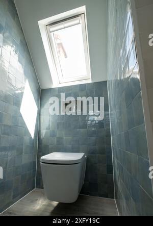 Kleine Toilette in Loft-Umbau mit cleverem Gebrauch der Traufe auf dem Dachboden. Architekt entworfen mit blauen Porzellan zellige Fliesen, weiße Wand hängende Toilette. Stockfoto