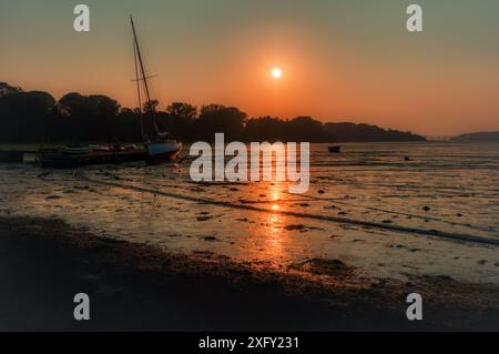 Sonnenuntergang bei Ebbe in Pin Mill, am Fluss Orwell, in der Nähe von Ipswich, Orwell Bridge in der Ferne, Suffolk, England, Großbritannien Stockfoto