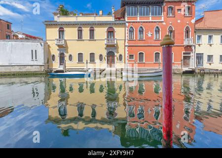 Gebäude reflektiert auf dem Wasser, Chioggia, Gemeinde der Metropolstadt Venedig, Veneto, Italien Stockfoto