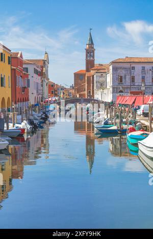 Die mehrfarbigen Fassaden der Gebäude am Vena-Kanal und im Hintergrund der Glockenturm der Kirche San Giacomo Apostolo in Chioggia, Gemeinde der Metropolstadt Venedig, Veneto, Italien Stockfoto